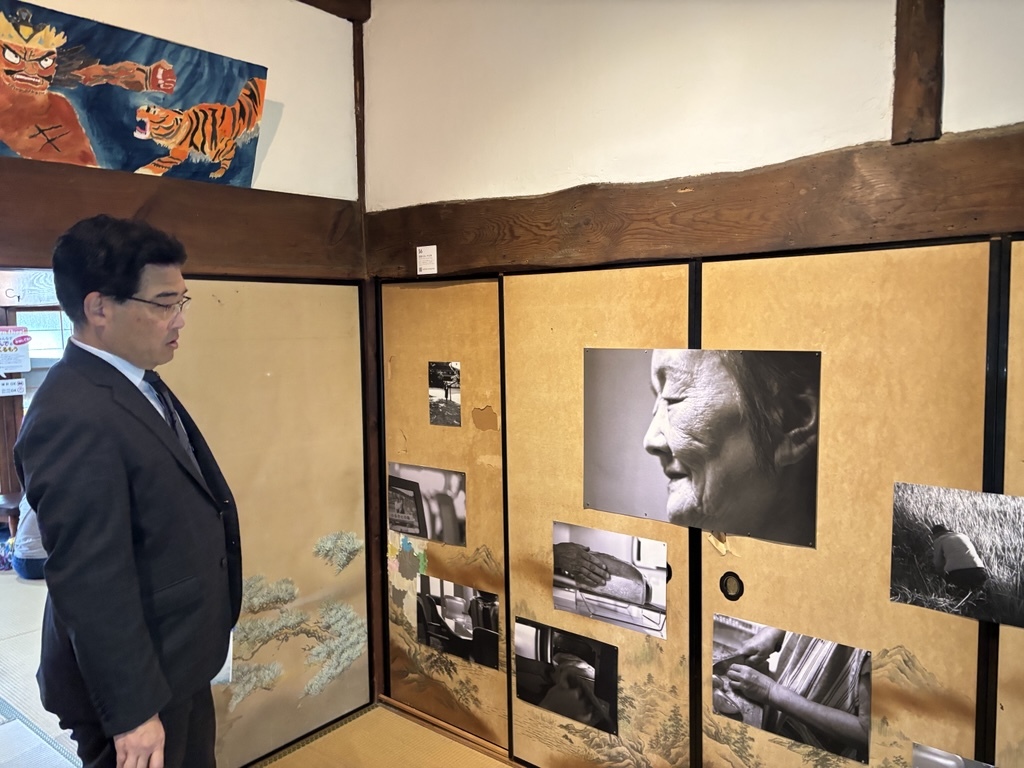 襖に張られた写真を鑑賞する市長の様子