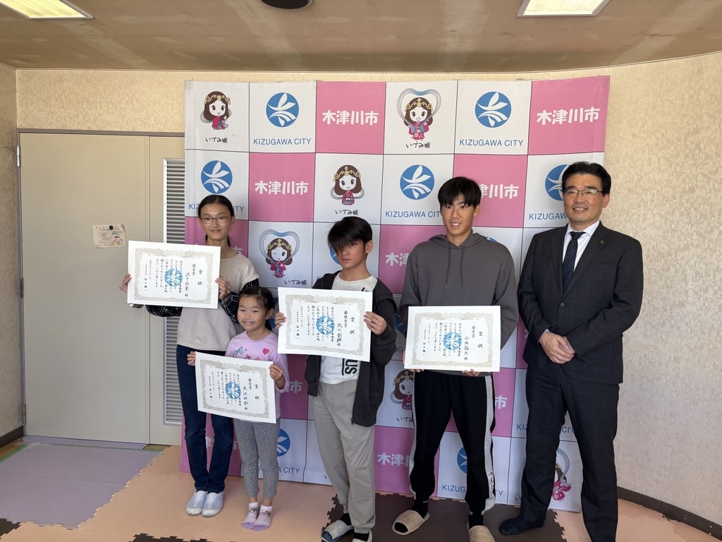 表彰状を持つ受賞者4名と市長が並んでいる写真