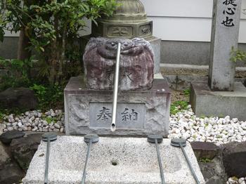 蟹が彫られた手水舎の写真