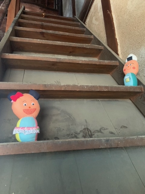 階段にいる「ぷく」と「マイ」のぬいぐるみの写真