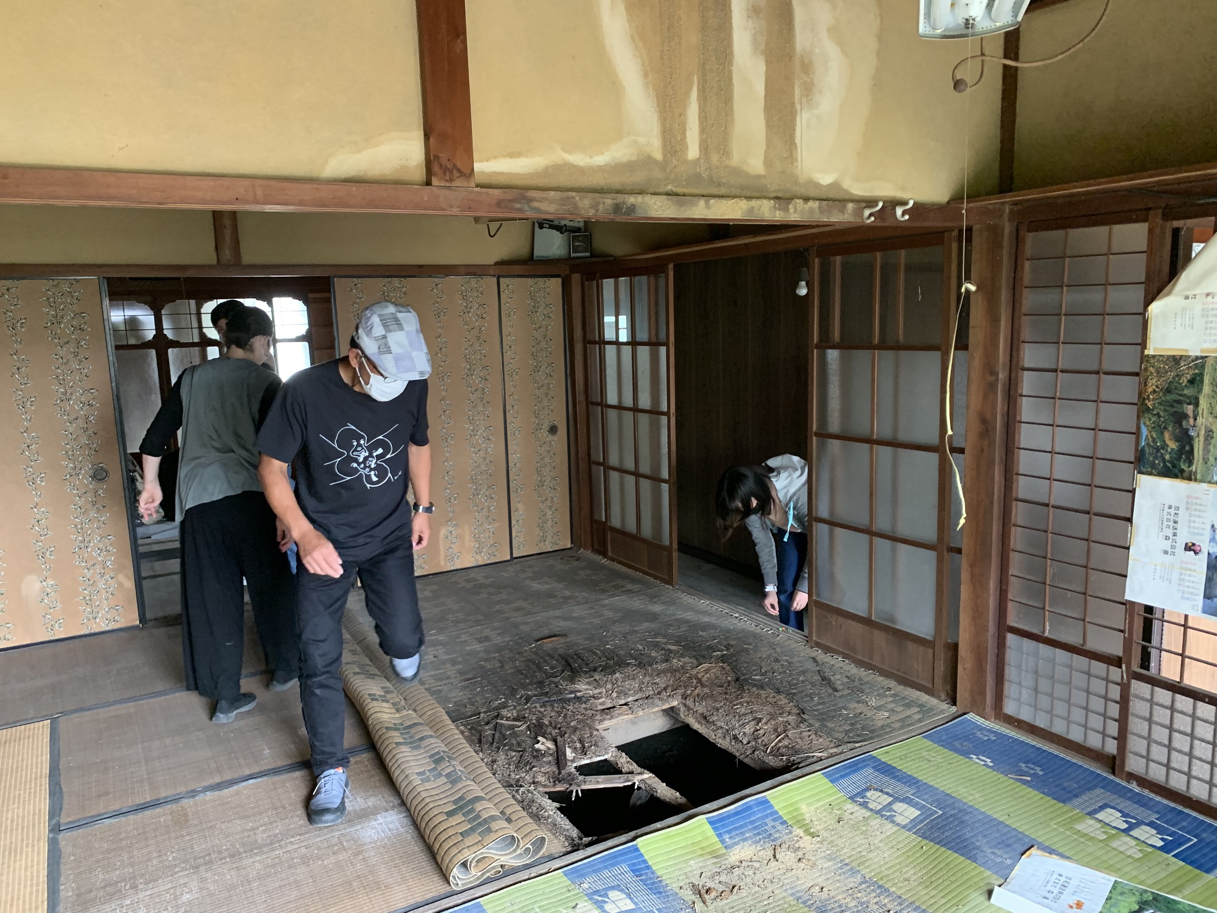 床に開いた穴の近くを歩く長谷川さんの写真