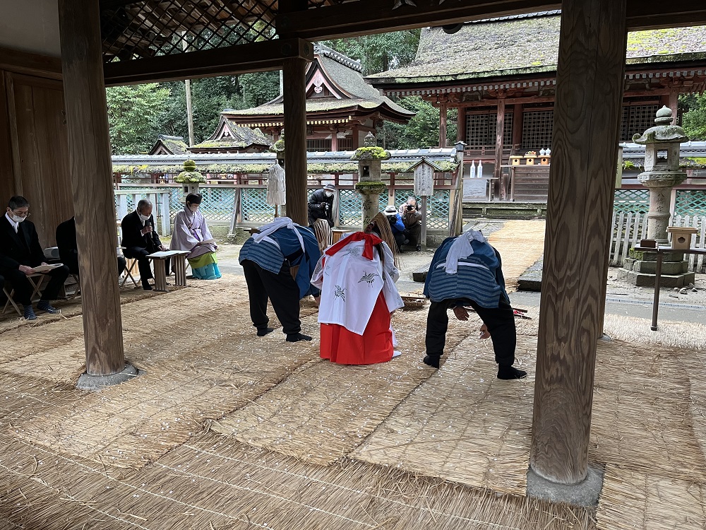 二人の実行組合員と巫女が歌に合わせて田植えを演じる様子