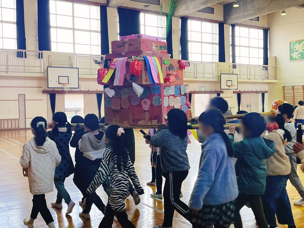 御輿を担いで体育館をまわる子どもたち