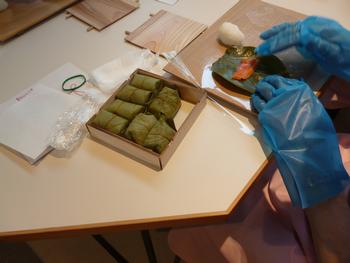 寿司を柿の葉で包んでいる手元の写真