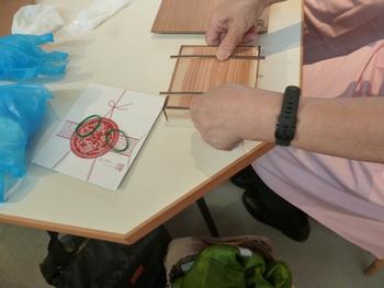 箱に詰めた柿の葉寿司を押している写真