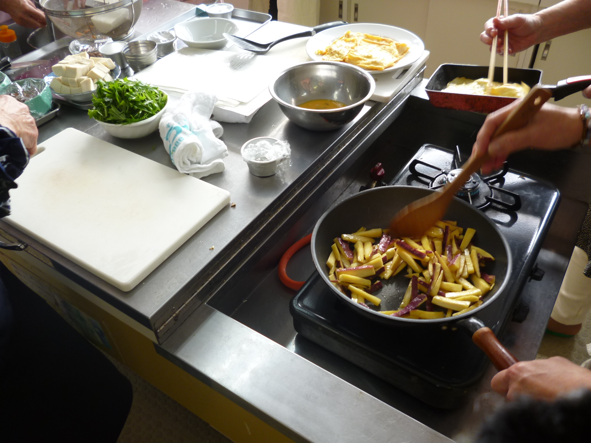 参加者が大学芋と薄焼き卵を作っている写真