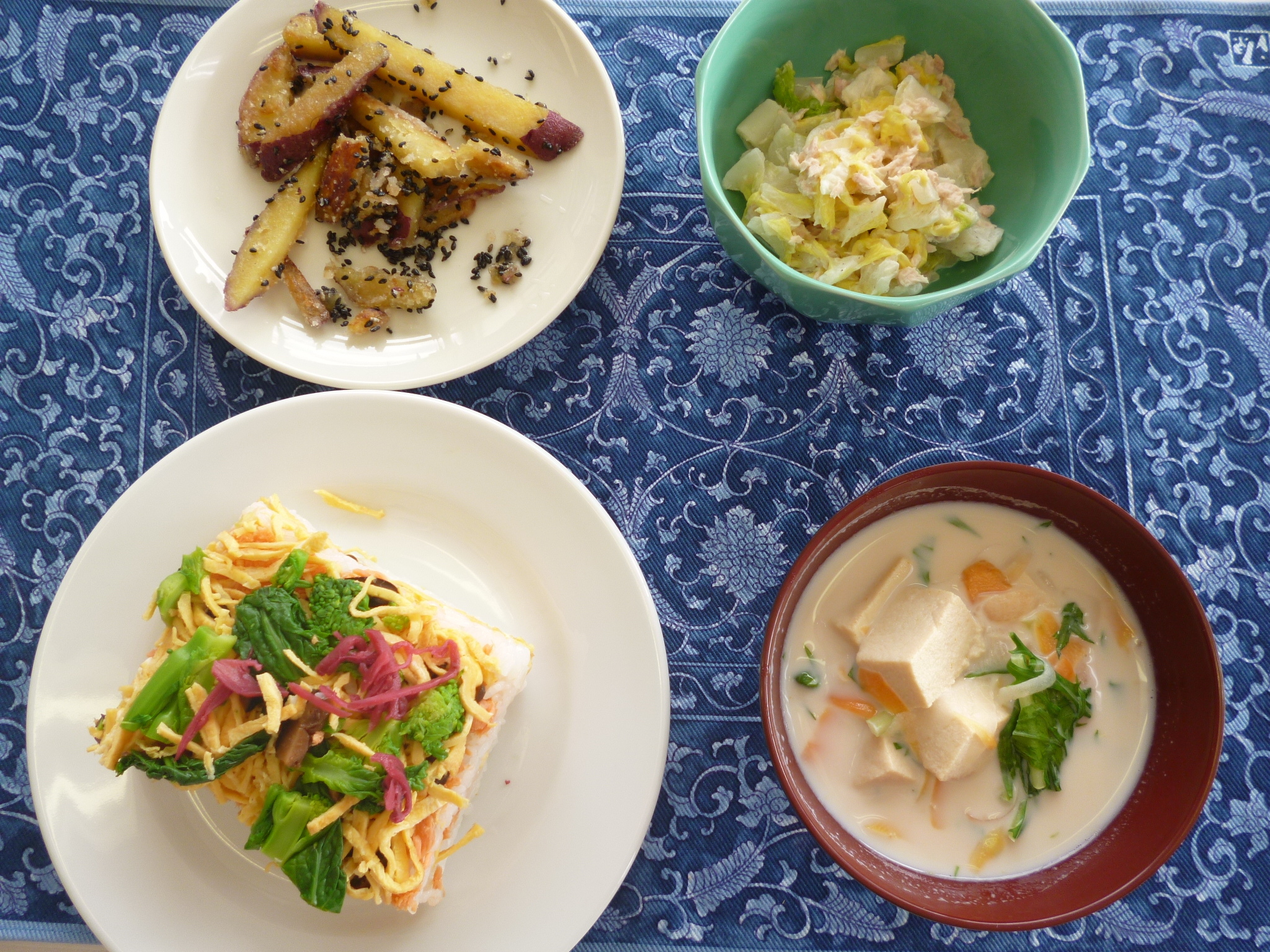 盛り付けた料理の写真（花菜の押しずし、白菜とツナのサラダ、高野豆腐のミルク味噌汁、かんたん大学芋）