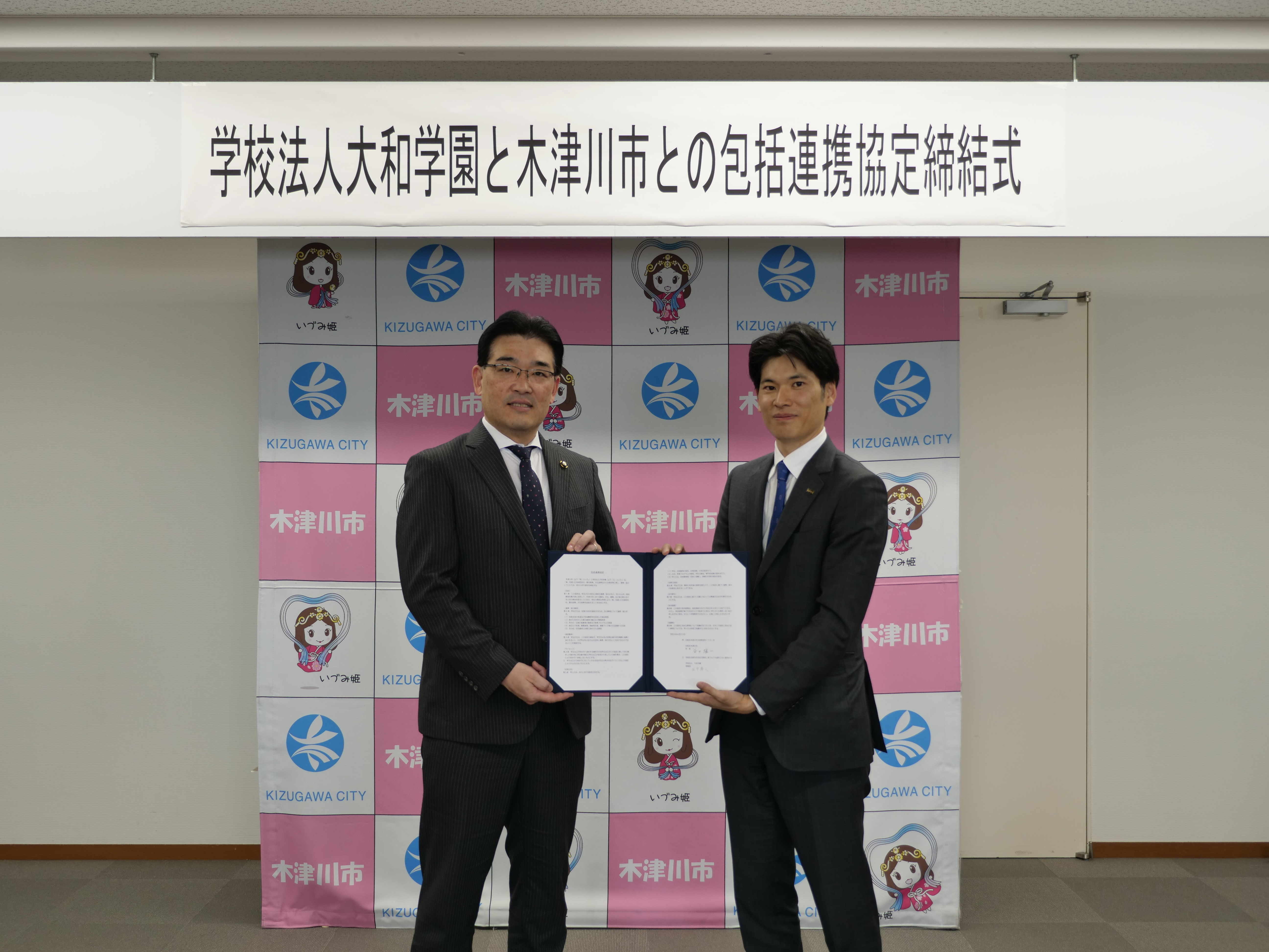 協定締結式での大和学園理事長と市長