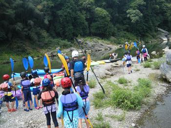 カヌー体験で河原を移動する児童の様子