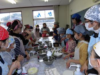 お菓子作り教室で、講師の話を聞く児童の様子